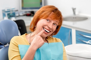An older woman pointing to her teeth
