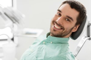 A young man sitting in the dentist chair smiling
