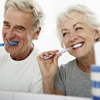 elderly couple brushing their teeth