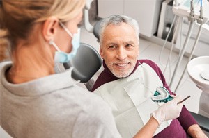 A dentist presenting a senior patient with dental impressions for dentures