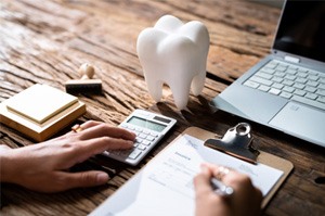 A patient filling out dental insurance forms at a desk