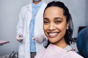 a woman sitting in a dental chair, smiling
