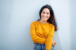 woman smiling after practicing dental implant care in Plano