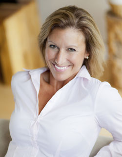 woman in white shirt smiling up at camera