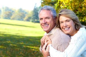 An older couple smiling outside.