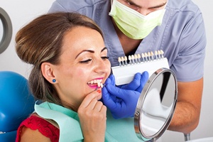 A patient comparing enamel shades with a dentist.