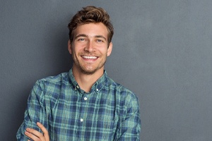 A man smiling with his arms folded.