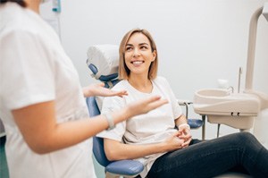 patient smiling while talking to dentist 