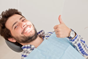 man smiling sitting in dentist chair