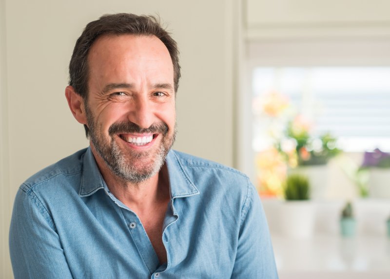 An older man smiling with his new dental veneers