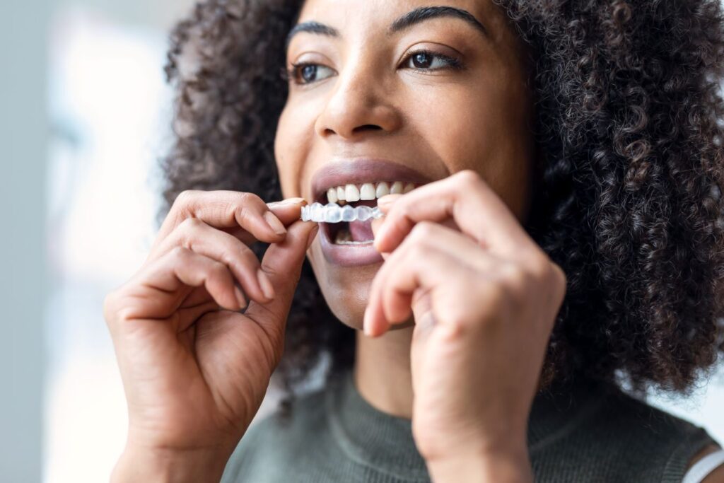 A woman putting on a clear orthodontic aligner